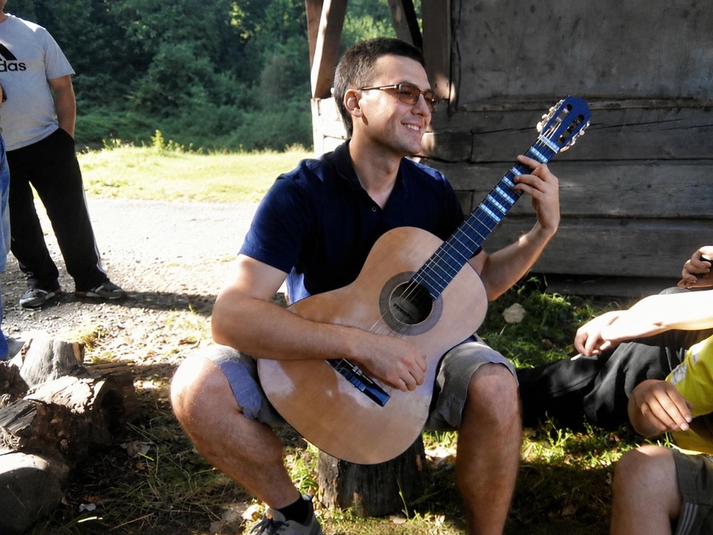 Dmytro playing guitar outdoors surrounded by friends in Chernivtsi, September 2014